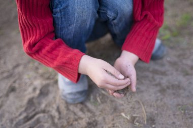 Çocuk ormanda kumla oynuyor..