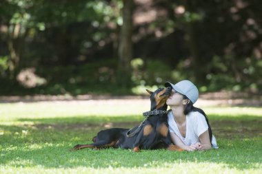 Kadın ağacın altında Doberman 'la rahatlıyor.
