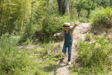 Genç kız ormanda yürüyor. 