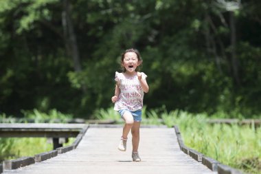 Patkta koşan sevimli Asyalı küçük kız. 