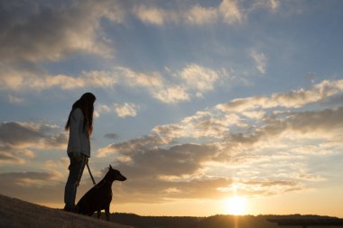 Doberman ve kadın silueti