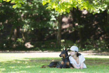 Kadın ağacın altında Doberman 'la rahatlıyor.