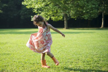 Parkta yürüyen sevimli Asyalı küçük kız.