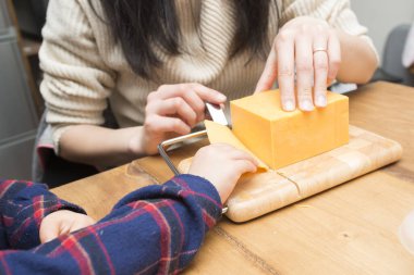 Peyniri kesen kadın ve çocuk