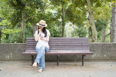 Bankta akıllı telefon kullanan bir kadın.