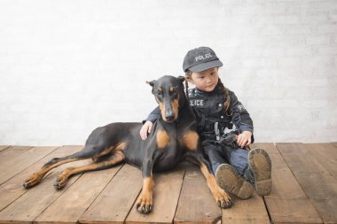 Güzel doberman ve polis kostümü giyen bir kız.