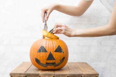 Bir balkabağı feneri yapmak için kadının elleri