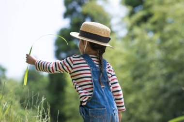 Kız saman şapkalı, parkta yaprak var. 