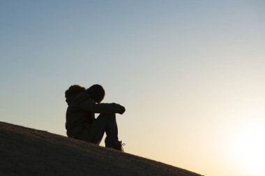 Dağ tepesindeki kızın silueti