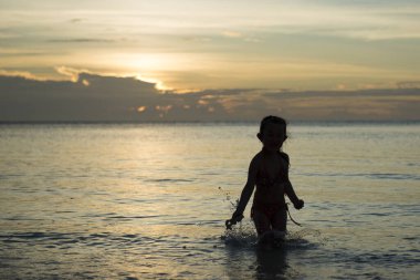 Gün batımında denizdeki küçük tatlı Asyalı kız 