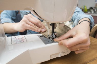 Dikiş makinesi kullanan kadın