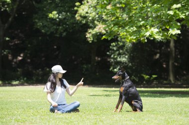 Yeşil parkta köpekli bir kadın
