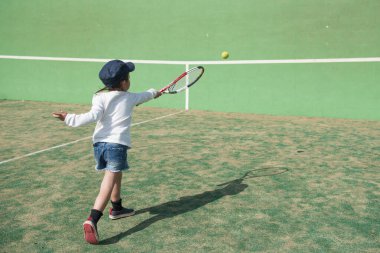 Mahkemede tenis oynayan küçük tatlı Asyalı kız.