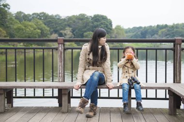 Anne ve kızı parkta bir bankta dinleniyorlar.