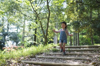 Asyalı kız orman yolunda yürüyor. 