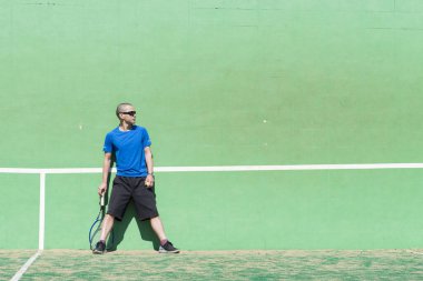 Sahada tenis oynayan adam.