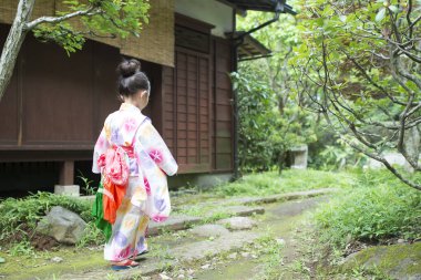 Parkta geleneksel Japon kimonosuyla küçük sevimli Asyalı kız. 