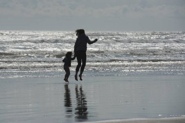 Anne ve kızı plajda oyna