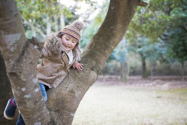 Ormanda oynayan Asyalı çocuk.