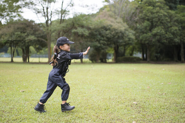 Девушка в полицейском костюме бегает по лужайке