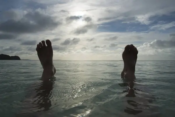 man feet  in the water of  sea