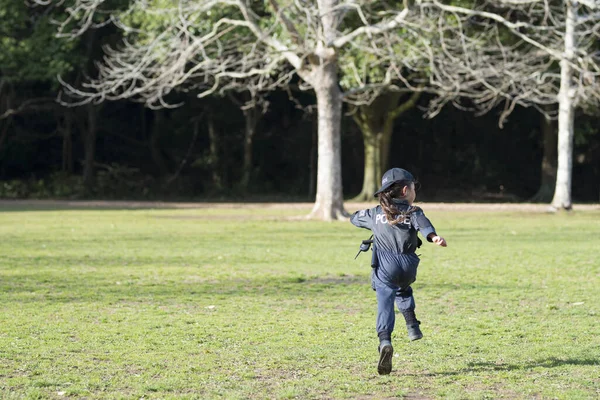 Happy Little Girl running in police costume