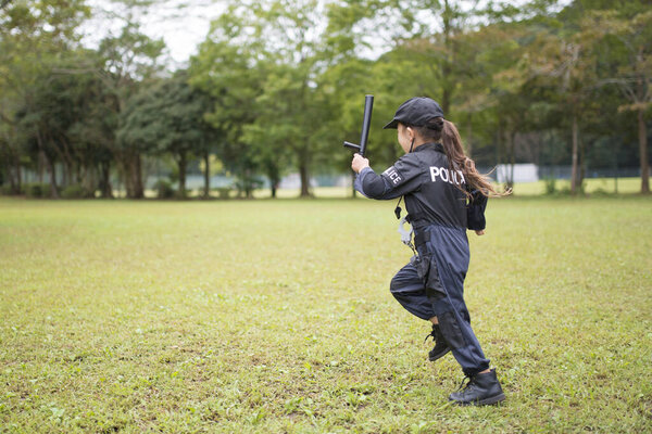 Девушка в полицейском костюме бегает по лужайке