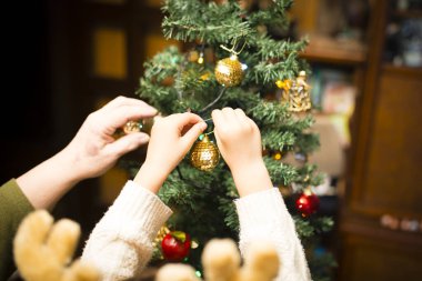 Anne ve kızı Noel ağacı süslüyorlar.
