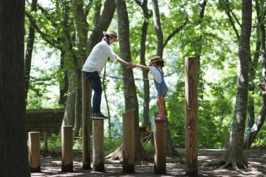 Anne ve kızı parkta oynuyorlar.