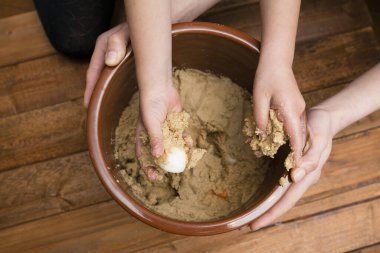 Ebeveyn ve çocuk elleri pirinç kepeği yapıyor.