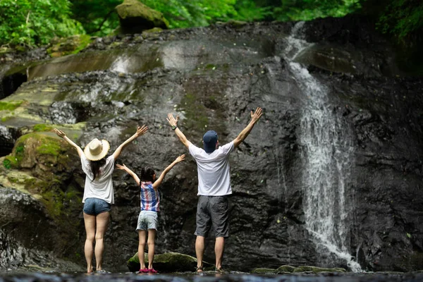 Baba, anne ve kız dağ deresinde oynuyorlar.