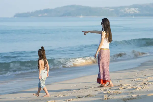 stock image Mother and daughter walking on the beach