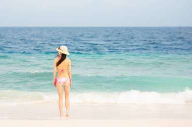 Bikini giyen Japon kadın sahilde dinleniyor.