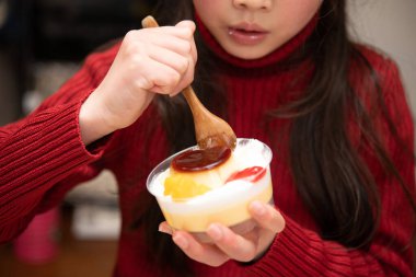 Tatlı bir puding yiyen bir kız