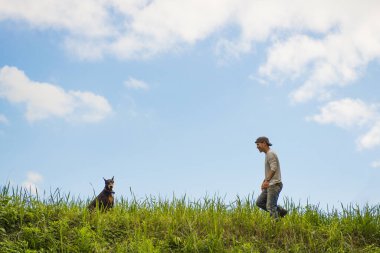 Bahçede köpekle oynayan adam.