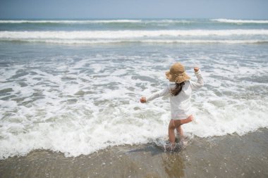 Kumsalda oynayan mutlu küçük kız