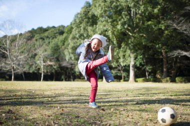 Küçük kız futbol topuyla oynuyor.
