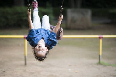 Parkta oyun parkında oynayan küçük tatlı Asyalı kız.