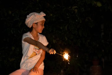 Kız havai fişeklerle oynuyor