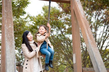 Anne ve kızı parkta oynuyorlar.