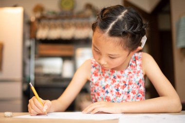 Not defterine yazı yazan Asyalı kız.