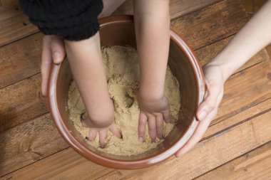 Ebeveyn ve çocuk elleri pirinç kepeği yapıyor.