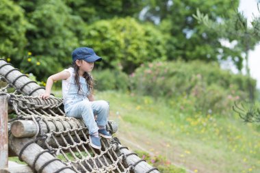 Parktaki oyun parkında küçük sevimli Asyalı kız. 