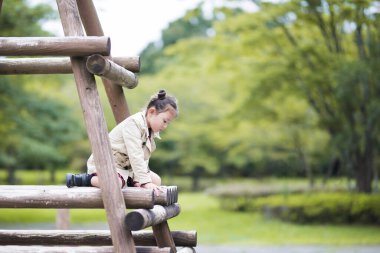 Parkta oynayan sevimli Asyalı küçük kız.