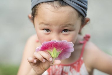 Çiçekli şirin bir Asyalı kızın portresi. 