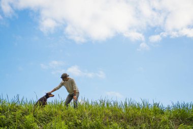 Bahçede köpekle oynayan adam.