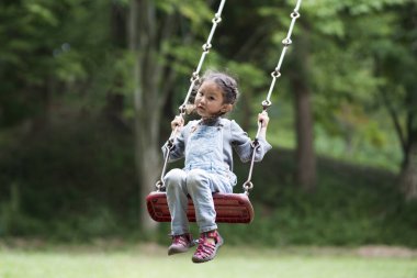  Parkta sallanan Asyalı kız.