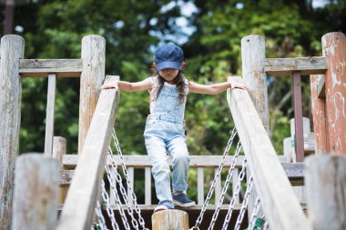 Küçük kız çocuk parkına tırmanıyor 