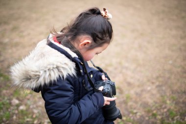 Ormanda kamerası olan küçük bir kız.
