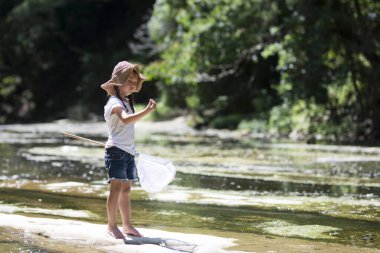 Küçük mutlu kız nehirde oynuyor